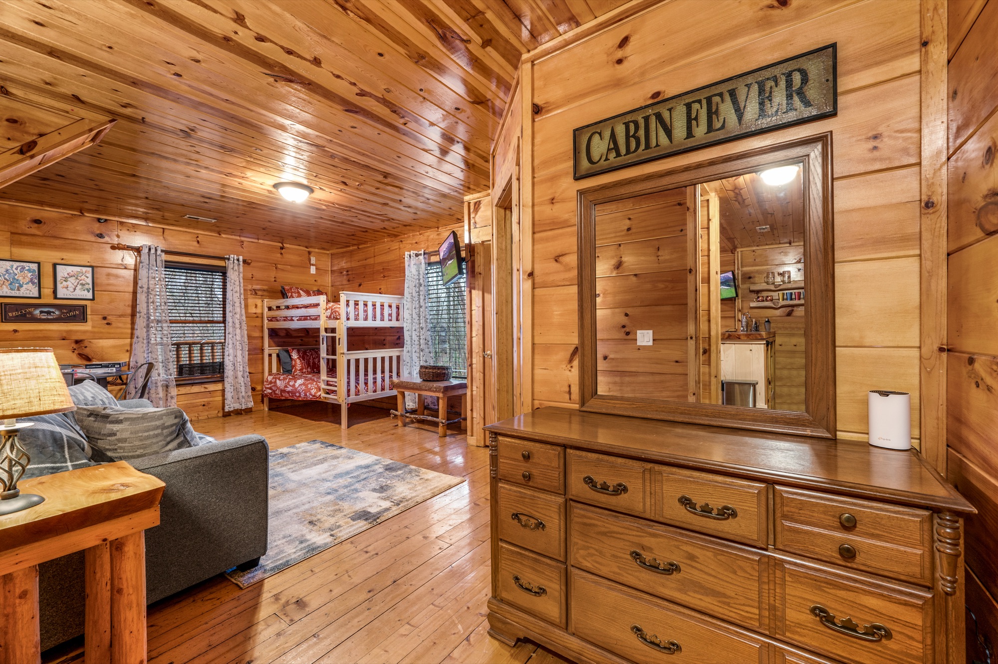 Wider view of the Bearadise bunk room, with the sleeper sofa, bunk beds, and dresser all in frame